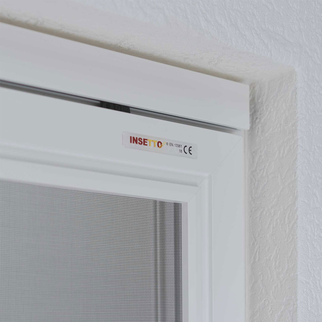 Fliegengitterschiebetür montiert an einem weißen Fensterrahmen
