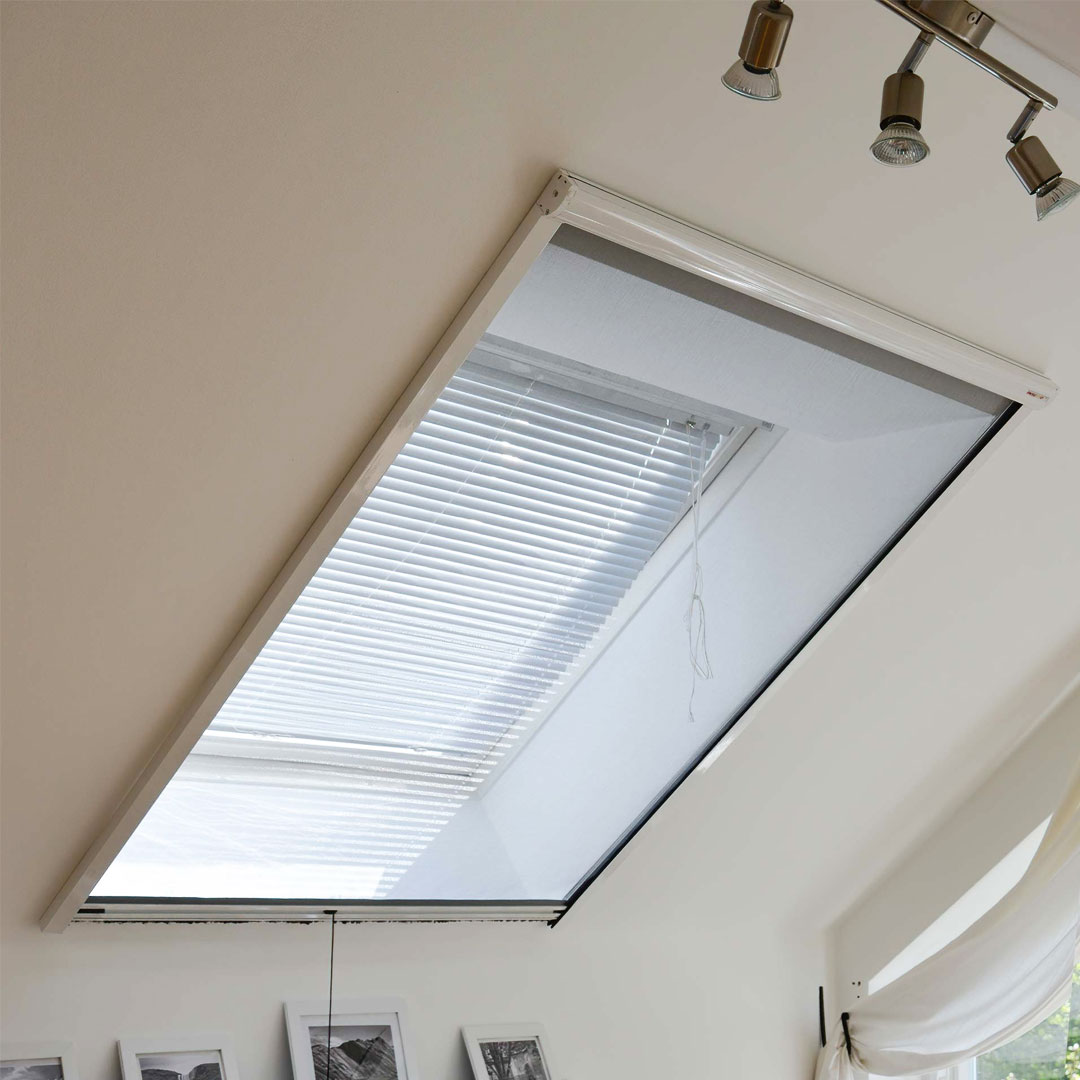 Dachfenster mit Insektenschutz an heller Wand