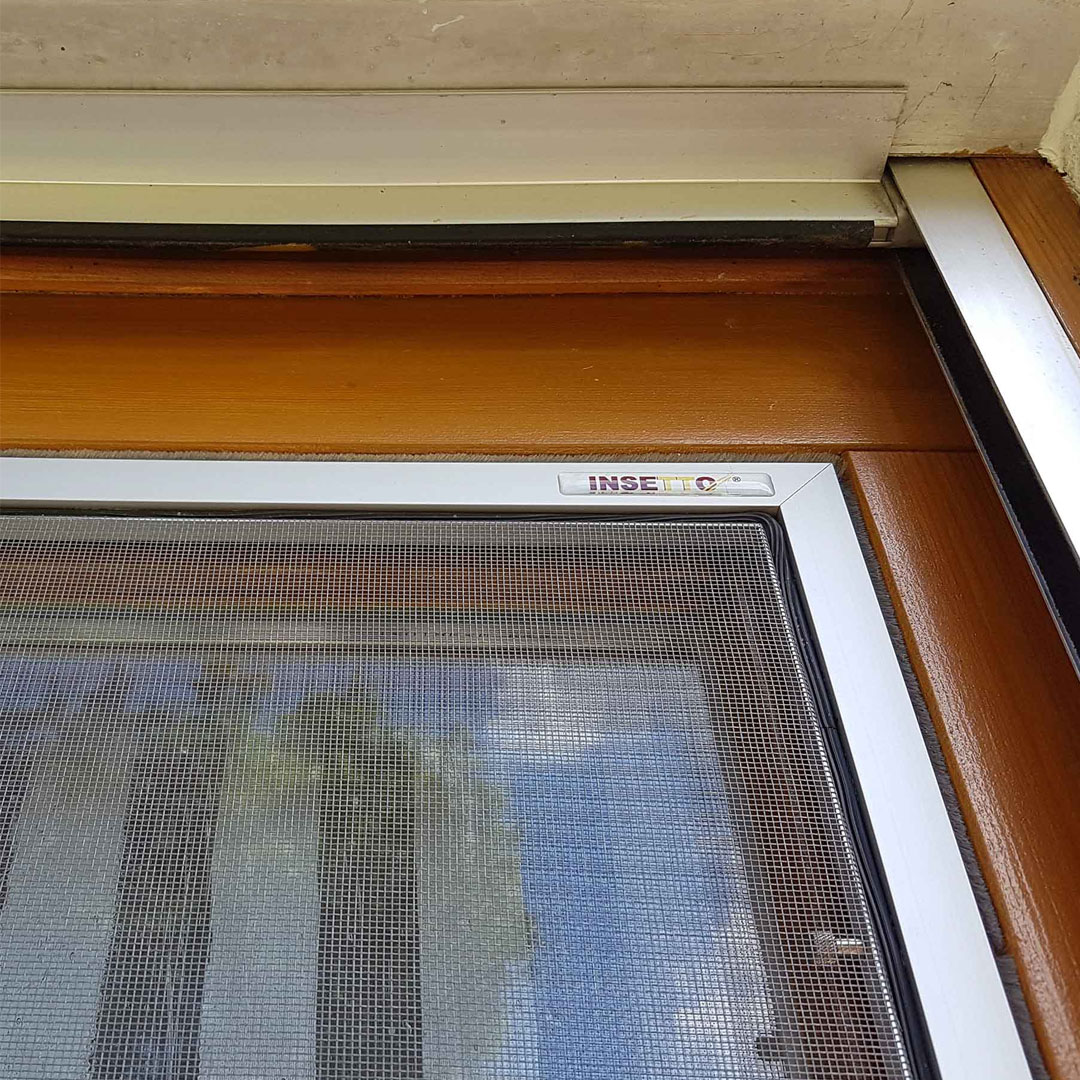 Insektenschutzgitter installiert in einem Holzfensterrahmen