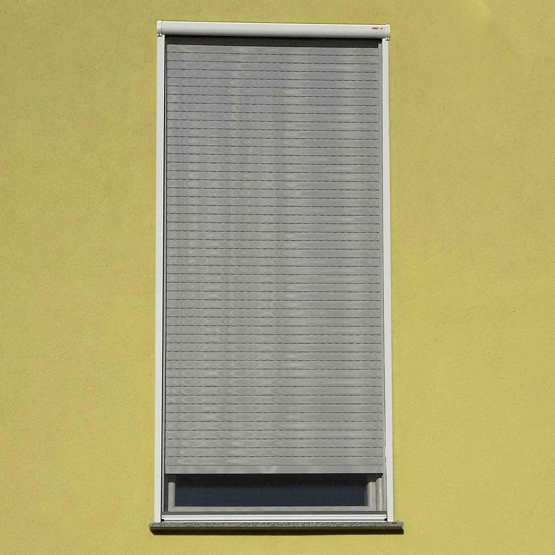 geschlossener Insektenschutzrollo an gelber Hauswand