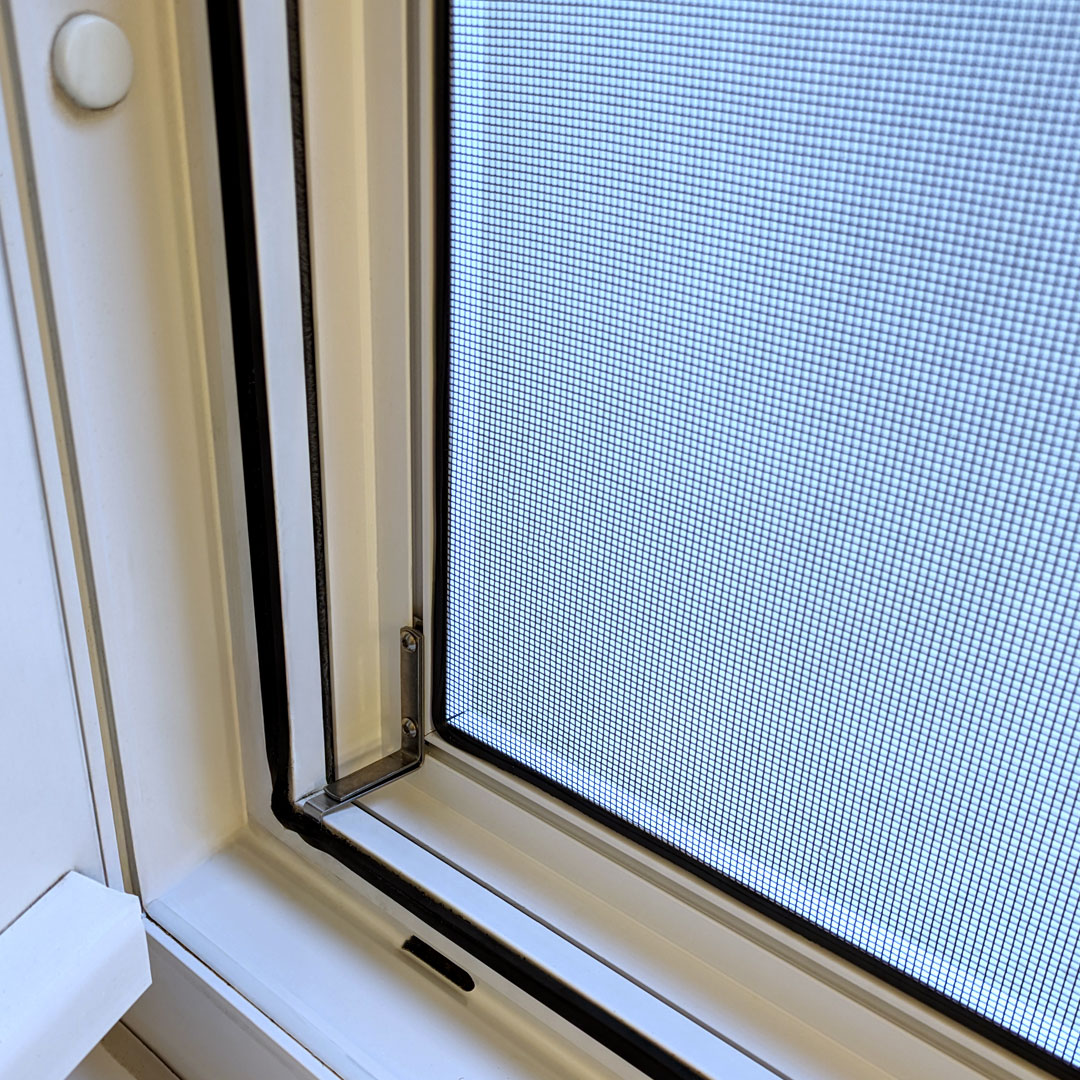 Insektenschutzgitter an hellem Fensterrahmen montiert