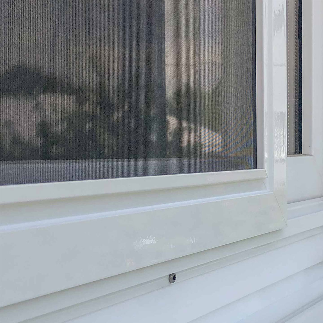 Fliegengitterschiebetür an weißem Fensterrahmen außen