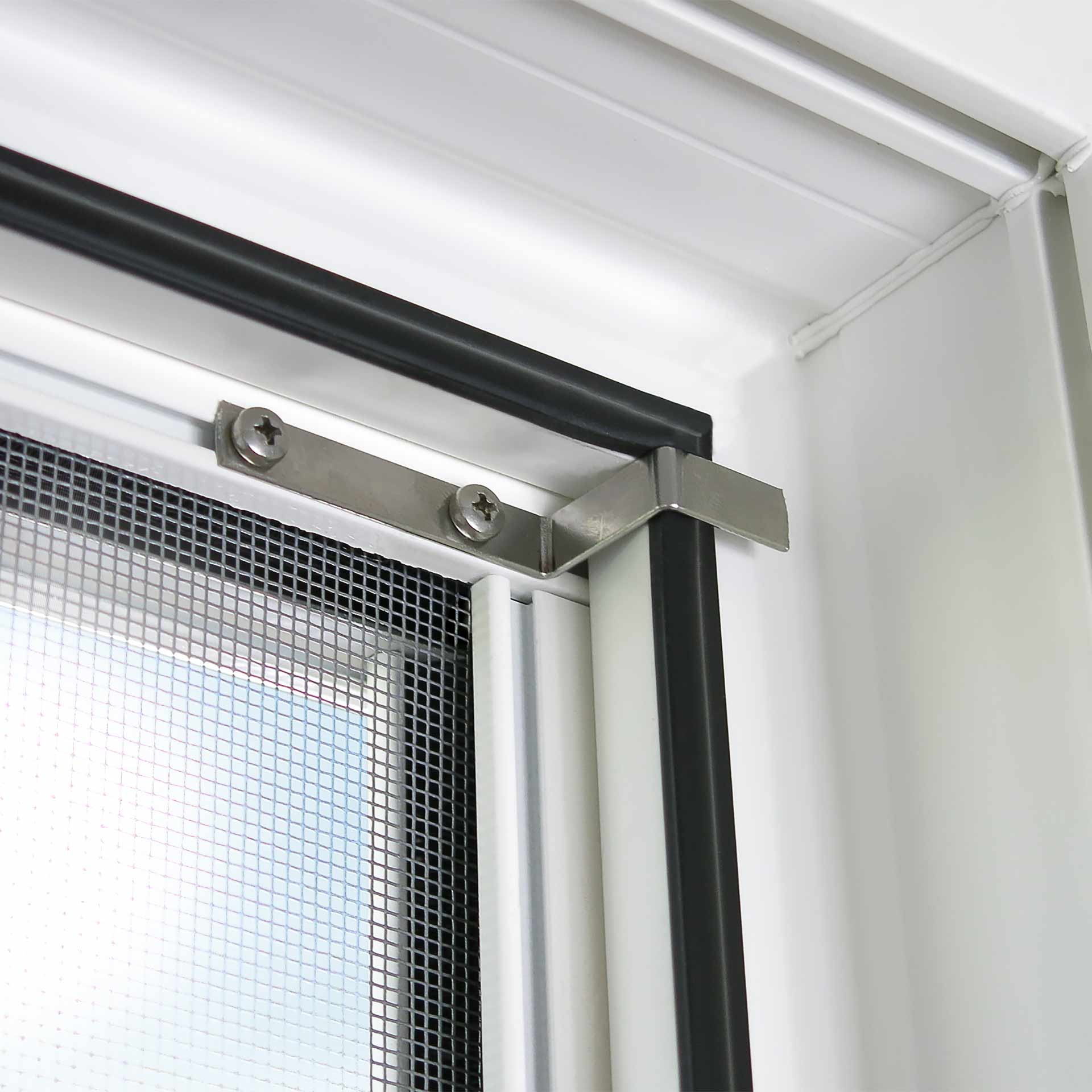 Fliegengitter befestigt an Fensterrahmen mit Metallklammern und Dichtung.