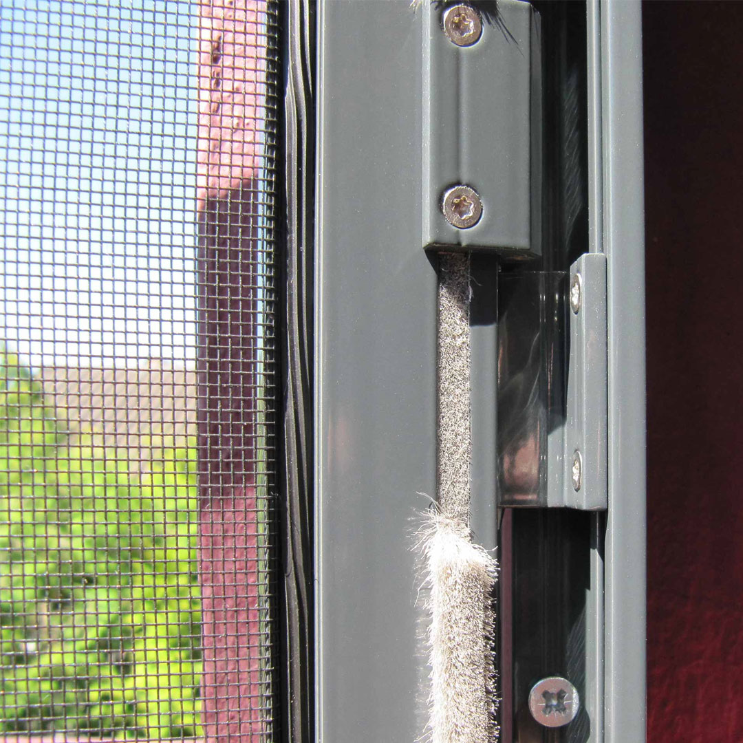 Fliegengitterrahmen in Fensterrahmen mit sonniger Aussicht.