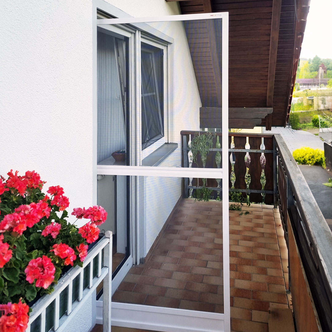 Offene Fliegengittertür, auf Balkon mit Blumen.