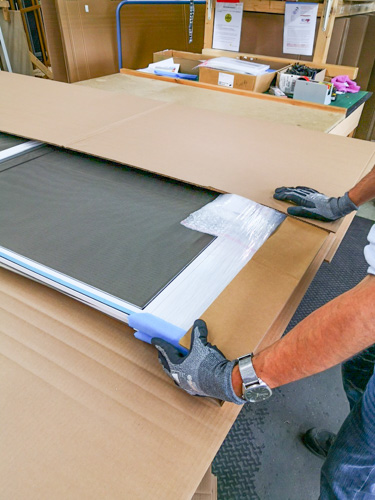 Person verpackt Fliegengitterrahmen.