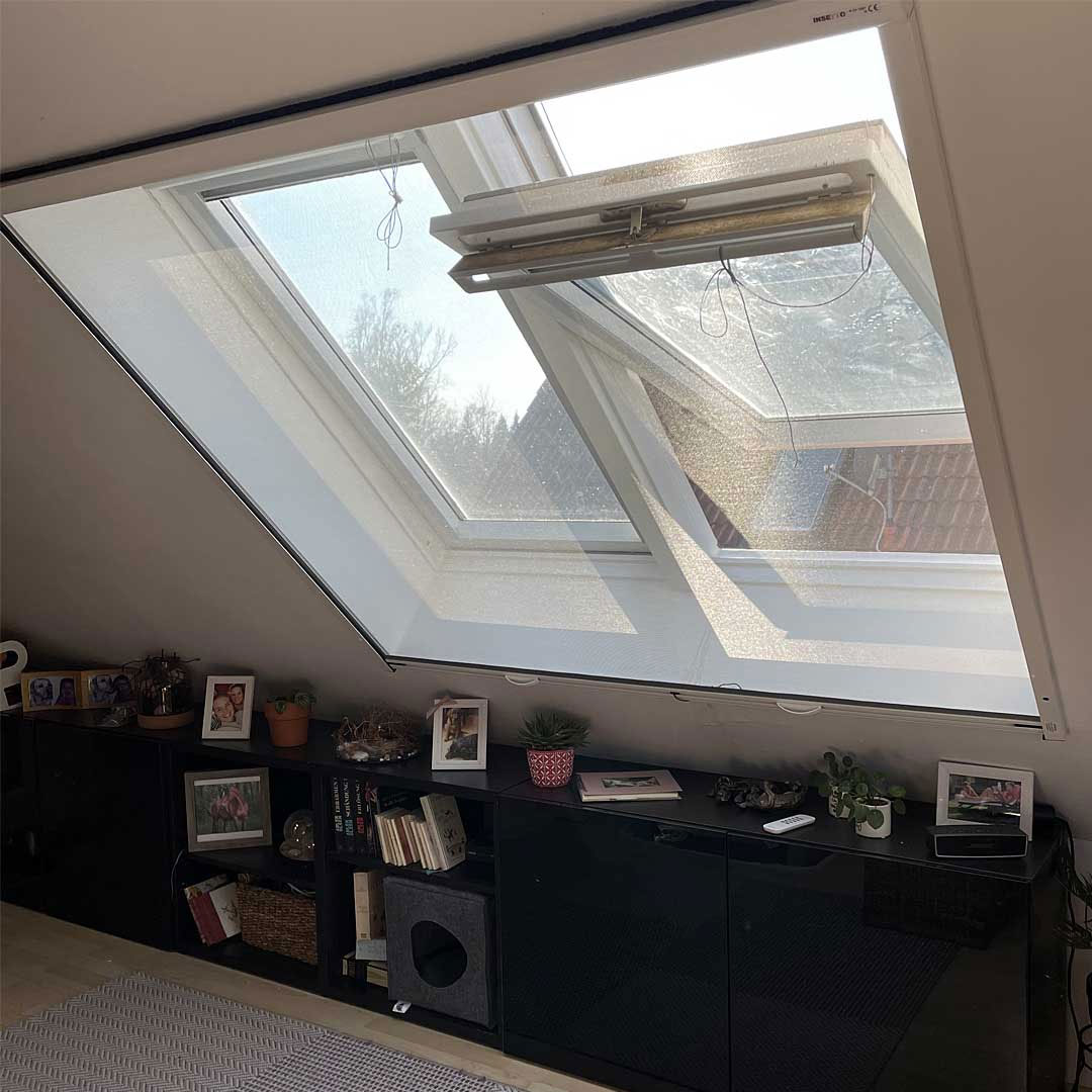 Dachfenster halb geöffnet mit Fliegengitter.