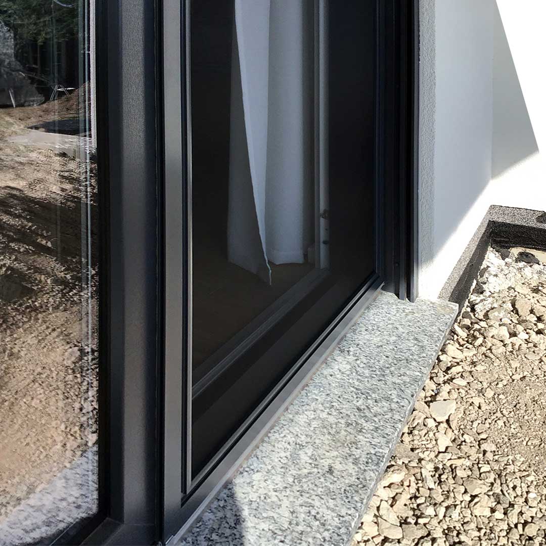 Fliegengitter, eingebaut in Fensterrahmen, Schotterboden.