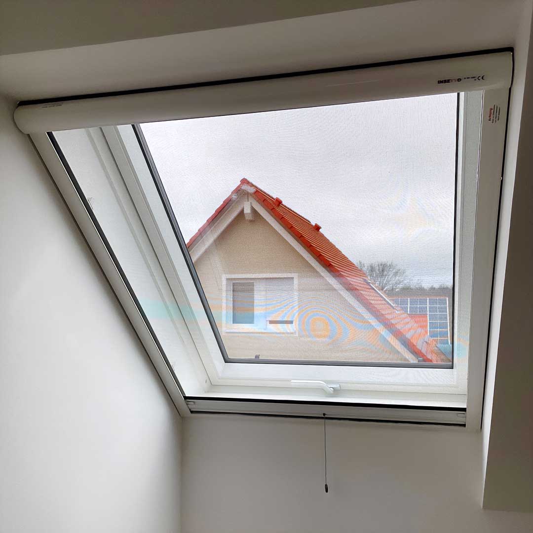 Insektenschutz-Rollo, geschlossen, Dachfenster mit Hausblick im Hintergrund.