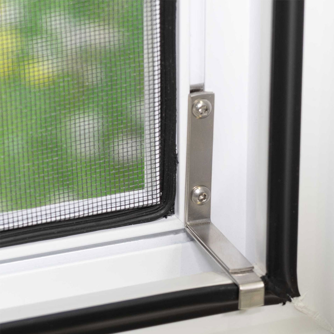 Fliegengitter, befestigt, an einem Fenster mit grünem Hintergrund.