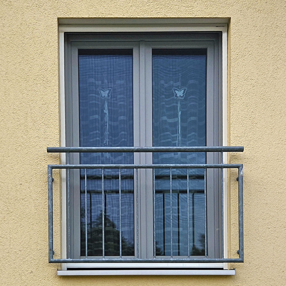 Insektenschutzrollo vor Fenster mit Metallgeländer