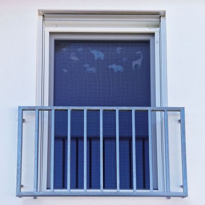 Insektenschutz an Fenster mit Metallgitter und Tieraufklebern