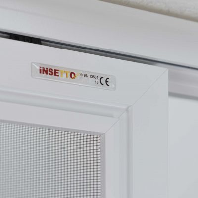 Fliegengitter an einem weißen Fensterrahmen innen.