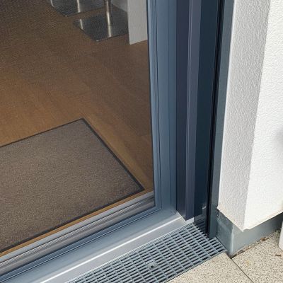 Fliegengitterschiebetür an einem modernen Gebäude montiert