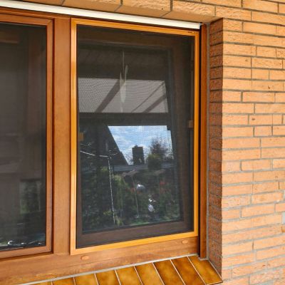 Insektenschutz an Holzfenster in Backsteinmauer
