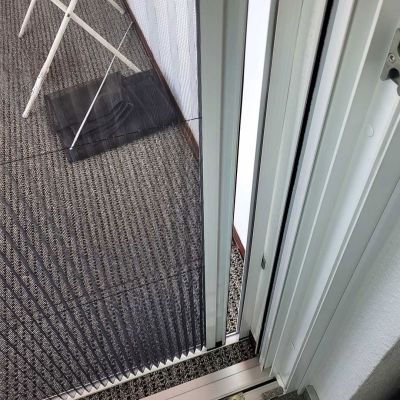 Plissee-Fliegengittertür führt zu Terrasse mit Teppichboden