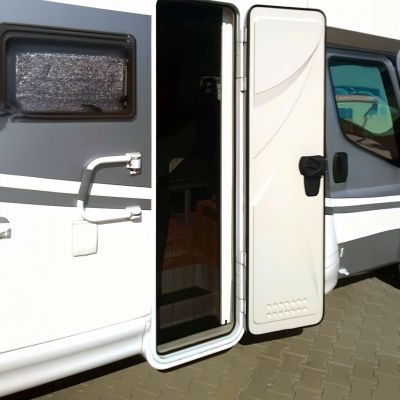 Wohnmobil mit offener Tür und angebrachtem Fliegengitter.
