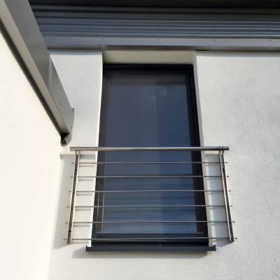 Fenster, geschlossen, mit modernem Edelstahlgeländer an Hausfassade.