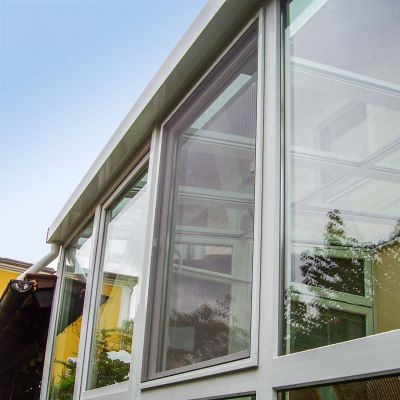 Fenster mit Fliegengitter in moderner Gebäudefassade eingebaut.