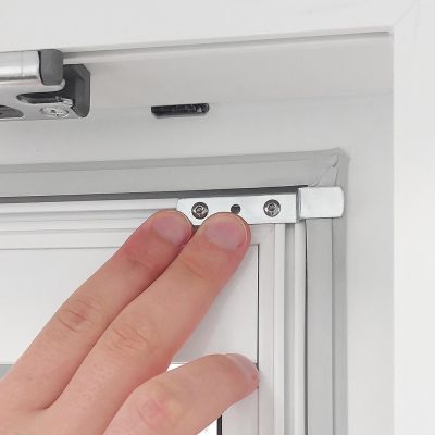 Hand befestigt Fliegengitterrahmen an Fenster mit Metallhalterung.