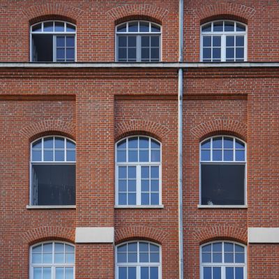 Insektenschutzrollos an Fenster von Fabrikgebäude