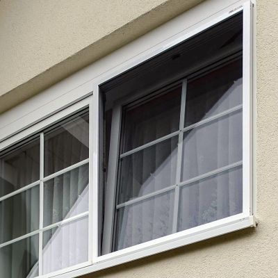 Fenster, gekippt, mit Fliegengitter in Hauswand eingebaut.
