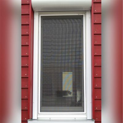 Fliegengitter an rotem Hausfenster mit weißem Rahmen.