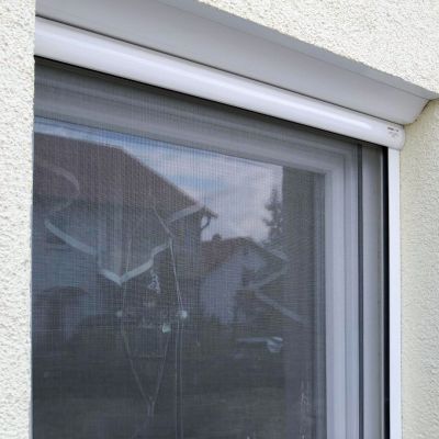 Fliegengitter vor einem geschlossenen Fensterrahmen installiert.