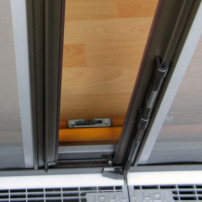 Fliegengittertür, geöffnet, vor Holzboden installiert.